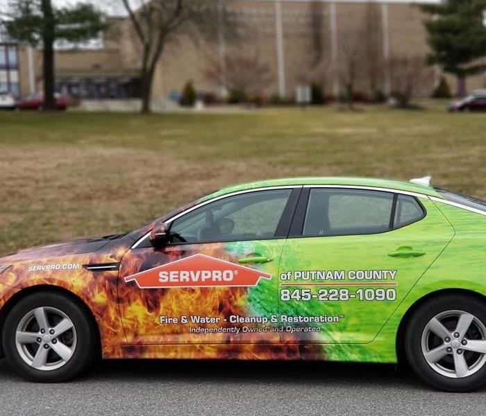A SERVPRO vehicle parked in front of a building