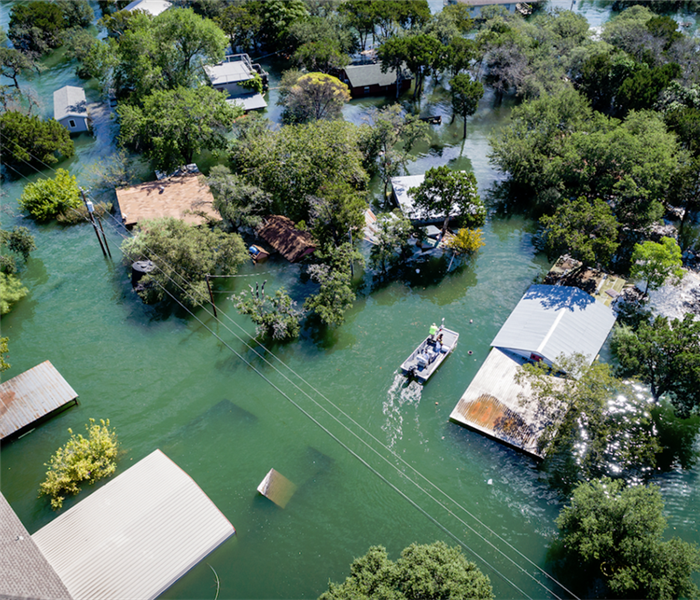 an overhead shot of a flooded neighborhood with water surrounding the houses